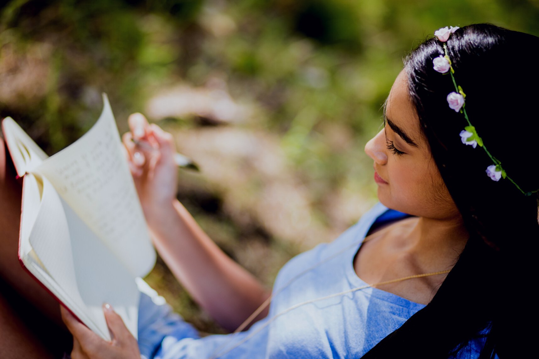 Mixed Race Person sitting outside writing in journal